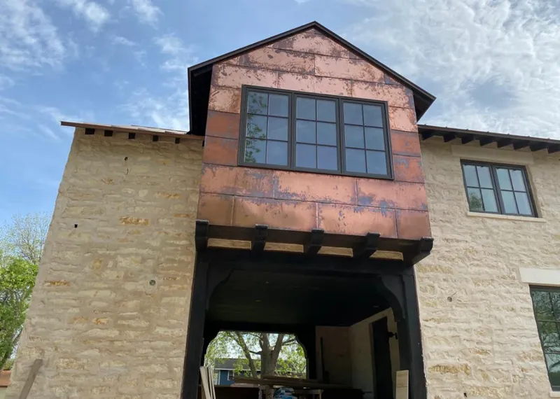 Copper metal panel facade on a stone building for Skylight Installation in Whitefish